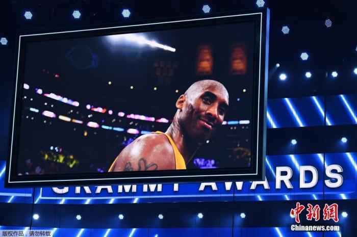 已退役NBA著名球员科比·布莱恩特(Kobe Bryant)内地时间26日在美国加利福尼亚州卡拉巴萨斯市因乘坐的直升机坠毁而遇难，年仅41岁。NBA这一天也有多场角逐举办，各支球队也用着各类方法哀伤科比。同日，美国第62届格莱美音乐奖在洛杉矶进行。 科比的球衣被悬挂在颁奖礼场馆斯台普斯中心，现场姑且增加致敬科比环节。图为格莱美颁奖现场大屏幕播放科比生前的画面。