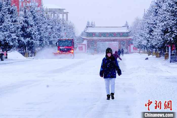 行人在雪中穿行。　王景阳 摄