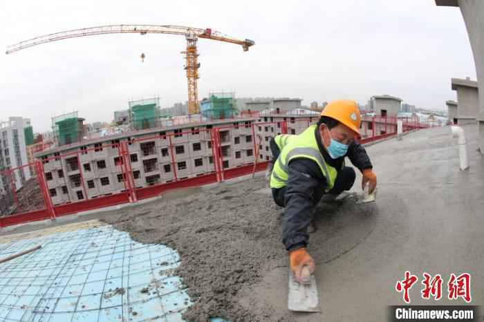 4月8日拍摄的几名中铁二十二局团体雄安公司工人正在北京“中国铁建·玉景阳光”共有产权房房顶举办混凝土浇筑功课。　孔祥文 摄