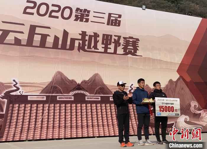 图为参加100公里越野赛的两名男子共同分享冠军喜悦。　刘小红 摄