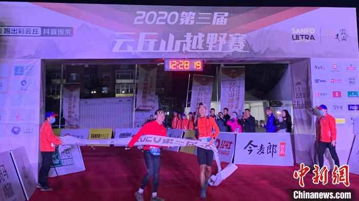 参加100公里越野赛的两名男子携手抵达终点。　刘小红 摄