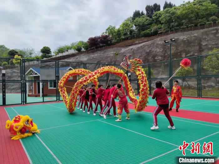 伍老家文化体育处事中心户外举动场上，住民正在举办舞龙练习 郝凌宇 摄