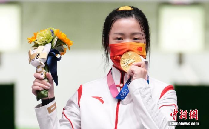 7月24日进行的东京奥运会女子10米气步枪决赛中，中国选手杨倩夺得冠军，为中国代表团揽入本届奥运会第一枚金牌。这也是本届东京奥运会降生的首枚金牌。图为杨倩隔着口罩亲吻金牌。/p中新社记者 杜洋 摄