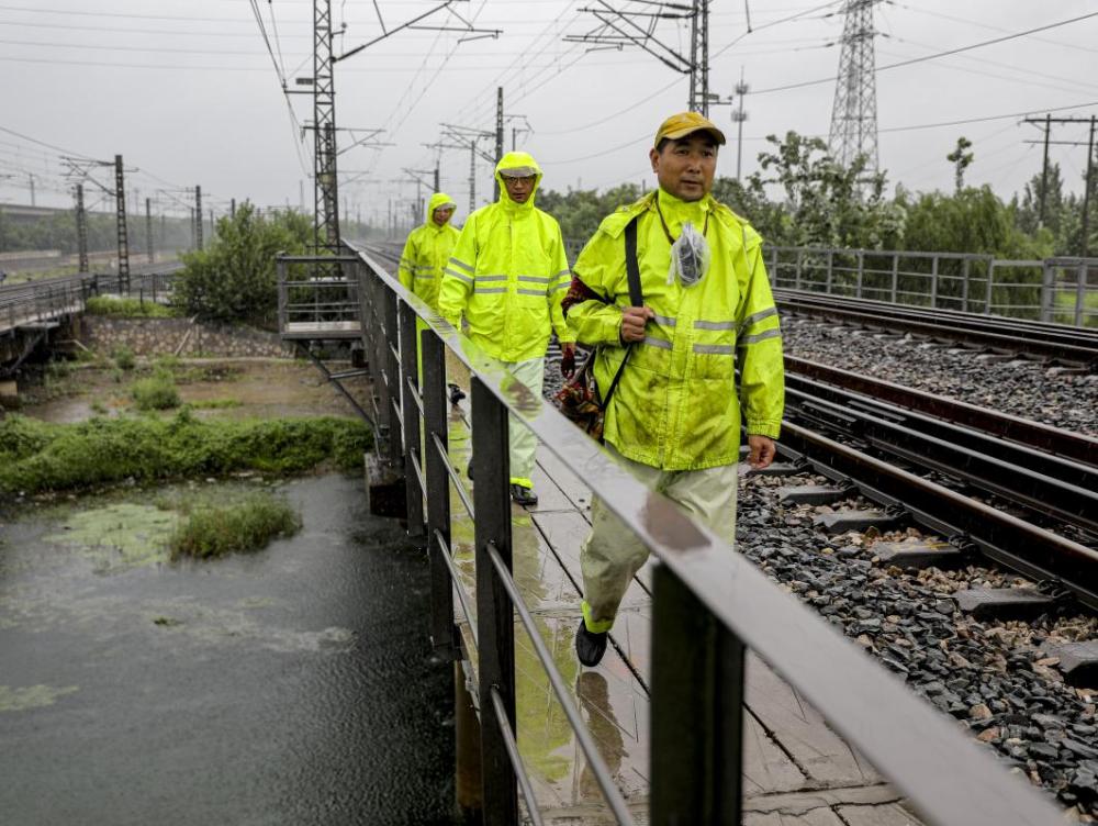天津迎暴雨天气 铁路事恋人员雨中全包围巡检线路保障运行安详